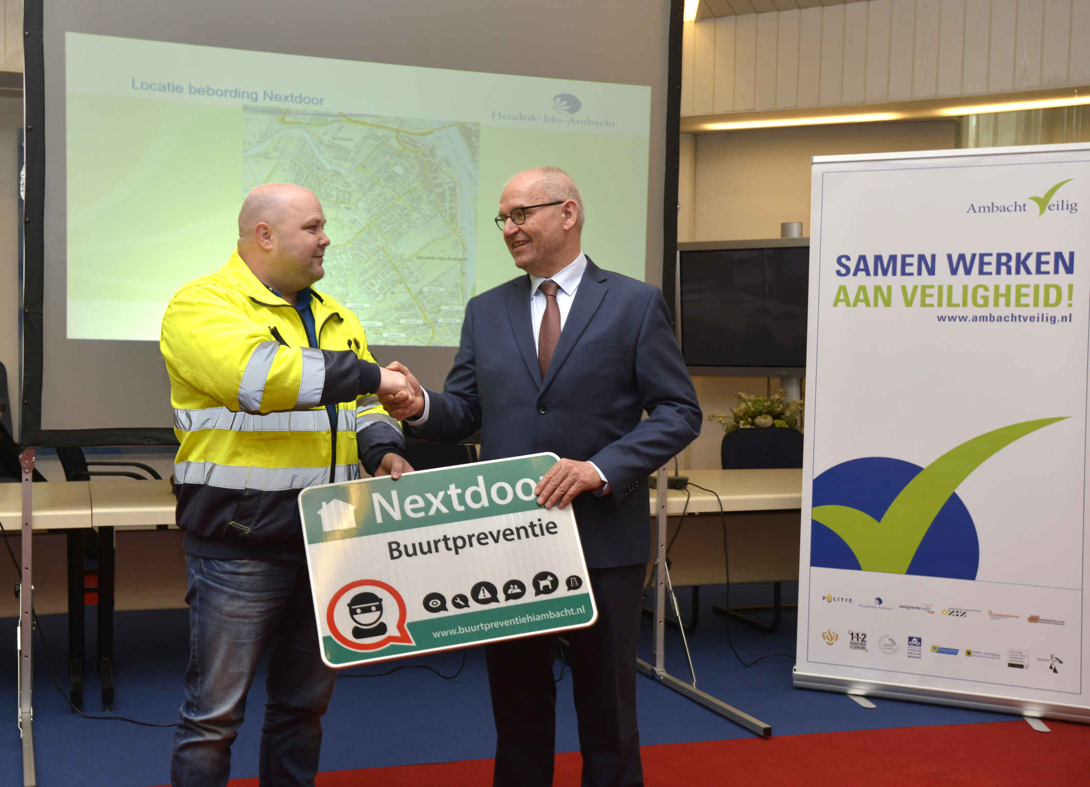 Burgemeester Jan Heijkoop overhandigt het eerste buurtpreventiebord aan Gertjan Kleinbloesem van buurtpreventie.